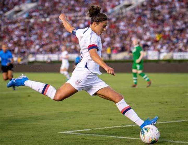 Carli Lloyd kicking a field goal with a pro NFL player