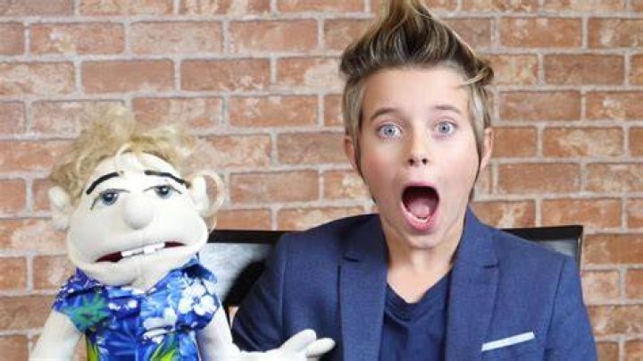 Gavin Magnus holding a puppet & gasping his breath.