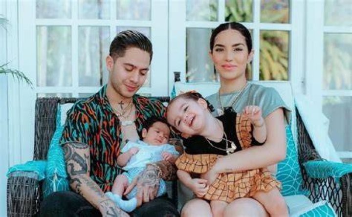 Kimberly Loaiza with her husband, JD Pantoja, signing the marriage documents while holding their daughter.