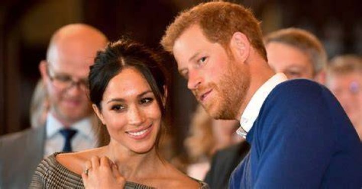 Prince Harry whispers to Meghan Markle as they watch a dance performance by Jukebox Collective in the banqueting hall during a visit to Cardiff Cas...